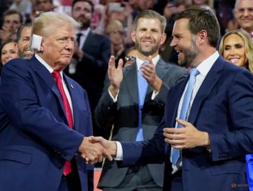 Republican presidential nominee and former U.S. President Donald Trump, and Republican vice presidential nominee J.D. Vance shake hands as Eric Trump watches during Day 1 of the Republican National Convention (RNC), at the Fiserv Forum in Milwaukee, Wisconsin, U.S., July 15, 2024. REUTERS/Elizabeth Frantz